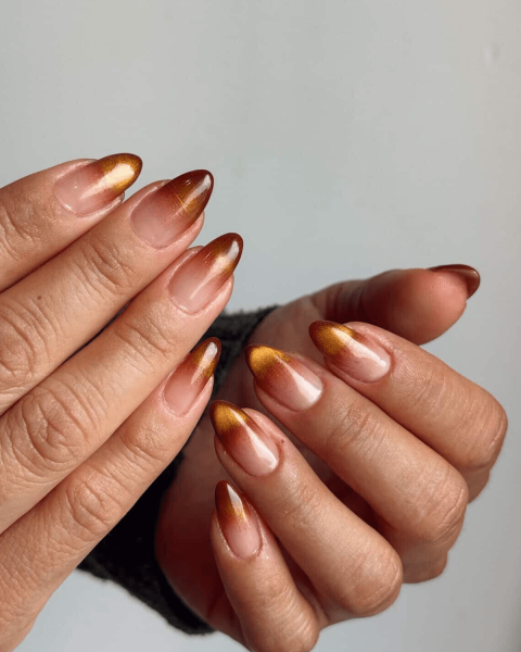 Close up of a brown and orange ombre manicure